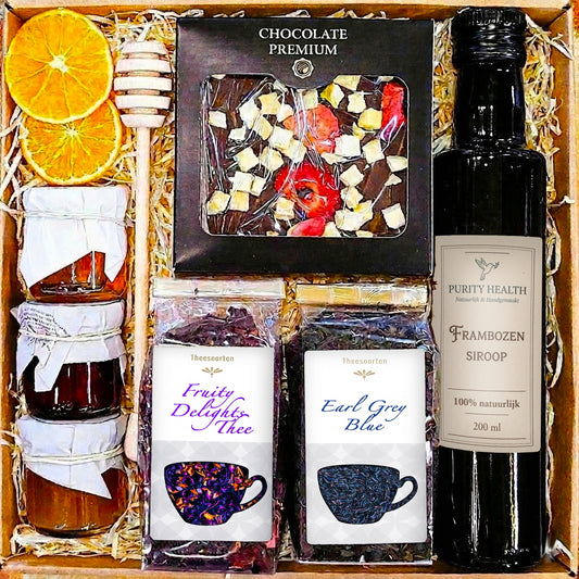 Geschenkmand met honing, chocolade, thee en siroop